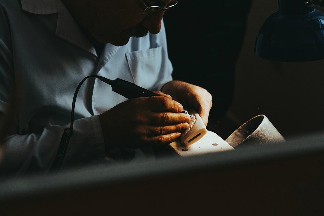 Watchmaker's hands adjusting a mechanical watch movement under a loupe